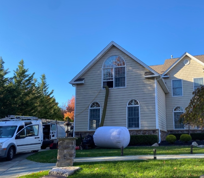Air duct cleaning technician working in New Jersey residential property using specialized equipment for efficient cleaning