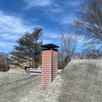 Chimney flue repair in New Jersey showcases a residential rooftop with a newly installed cap Chimney flue repair in New Jersey showcases a residential rooftop with a newly installed cap
