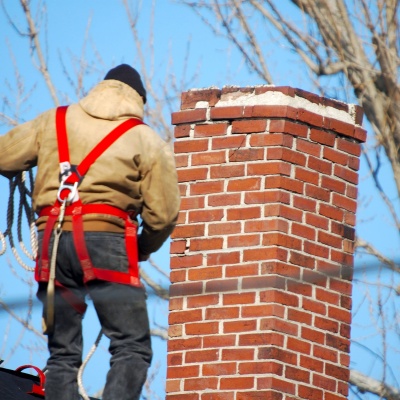 Chimney repair services in New Jersey with skilled worker securing roof safety equipment Chimney repair services in New Jersey with skilled worker securing roof safety equipment