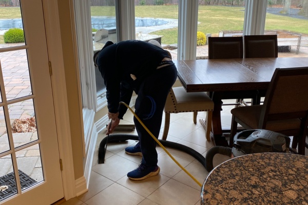 Home dryer vent cleaning process in a modern kitchen with large windows and outdoor view Home dryer vent cleaning process in a modern kitchen with large windows and outdoor view