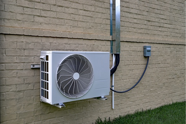 Maintenance tasks for a mini split air conditioning unit installed on a brick exterior wall in a residential area Maintenance tasks for a mini split air conditioning unit installed on a brick exterior wall in a residential area