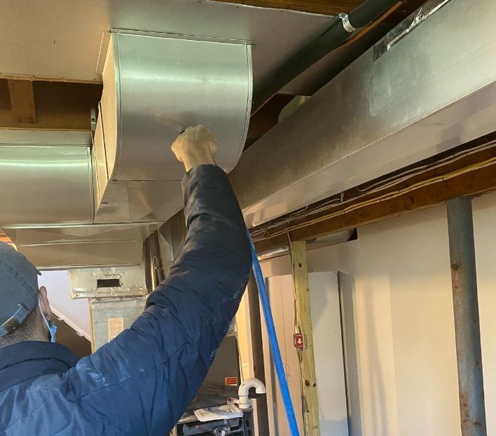 Residential HVAC duct coating service in New Jersey performed by a technician for improved air quality and energy efficiency